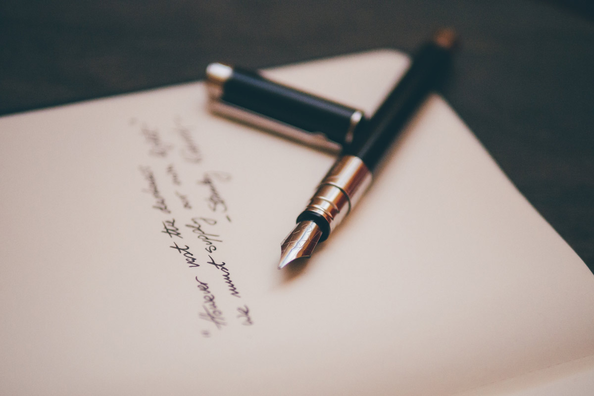 A fountain pen resting on a notebook